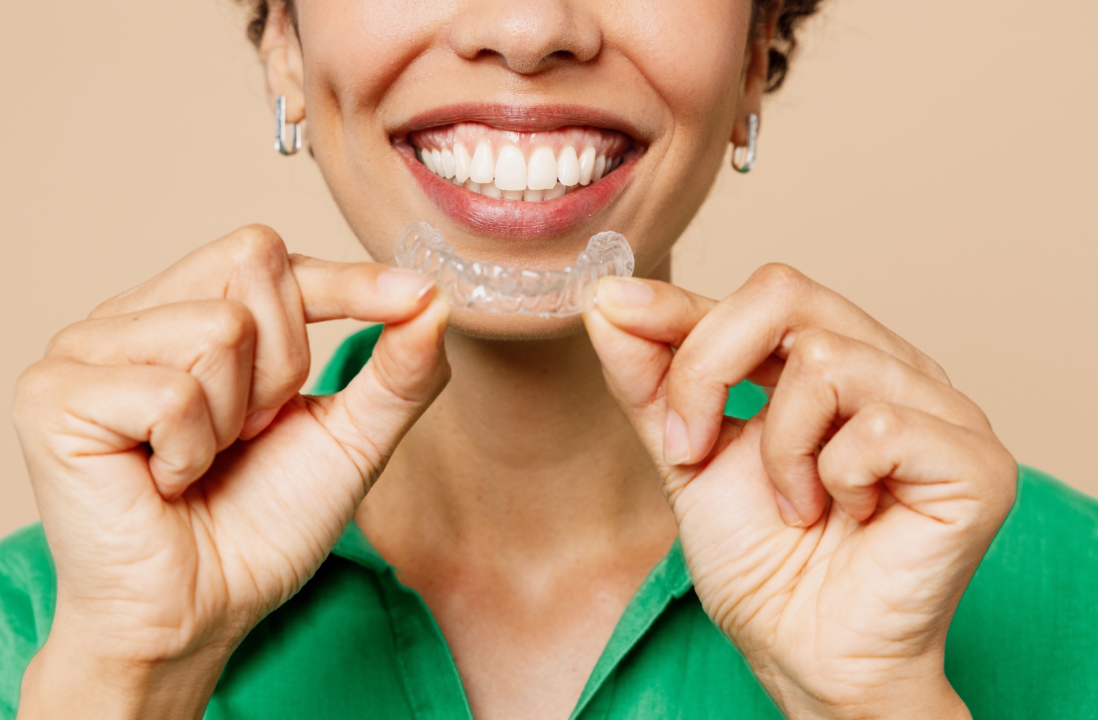 Smiling patient wearing clear Invisalign aligners.