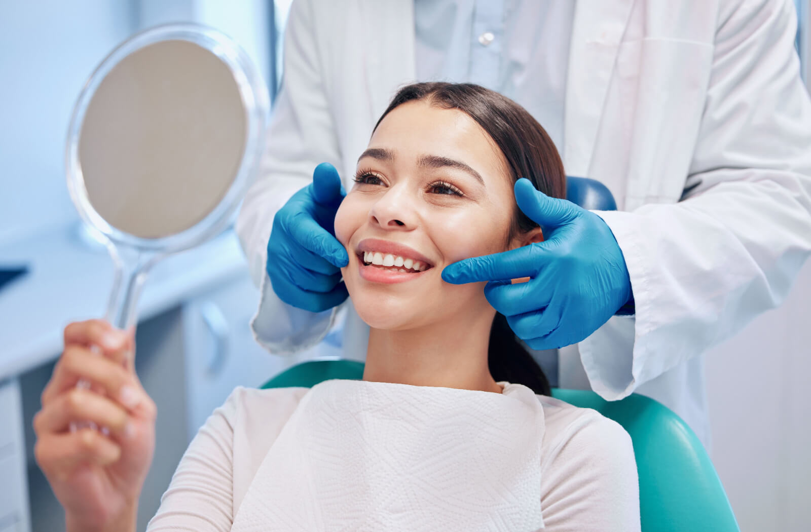 Femme souriant en admirant ses dents avec un miroir